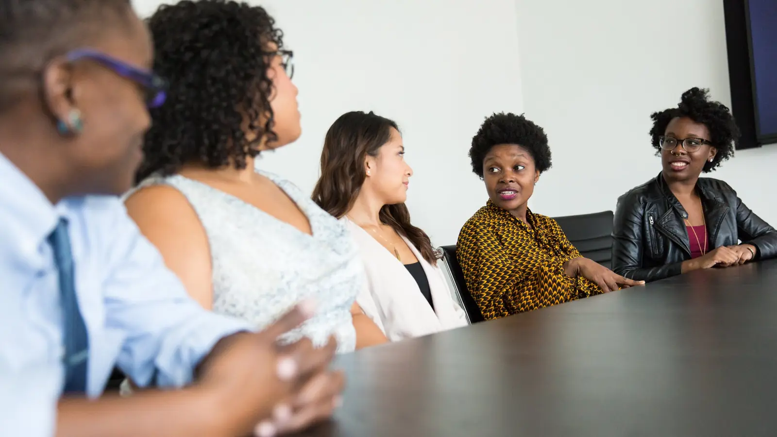 Colleagues seated around a boardroom table in discussion