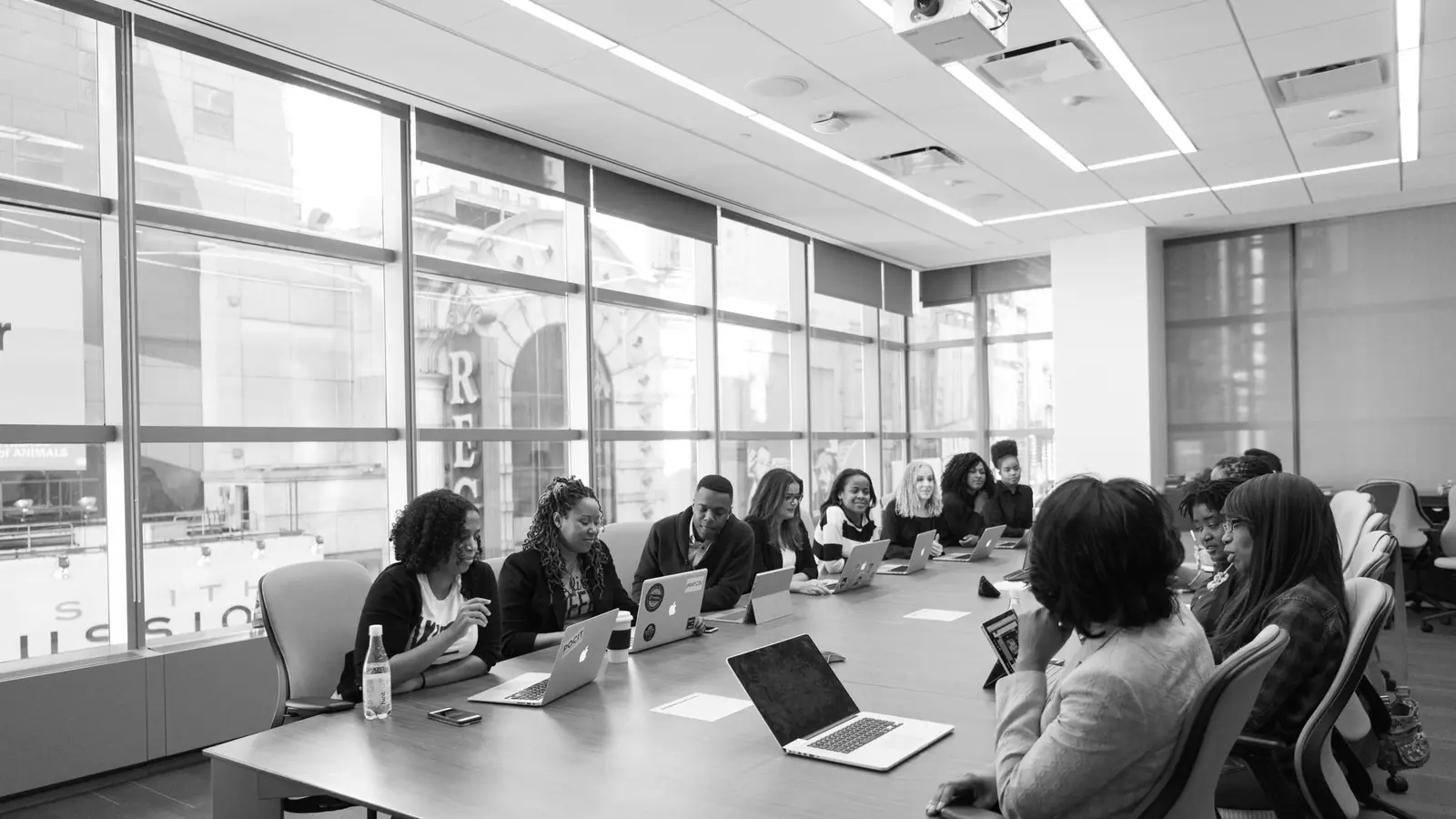A long boardroom table with people seated along it