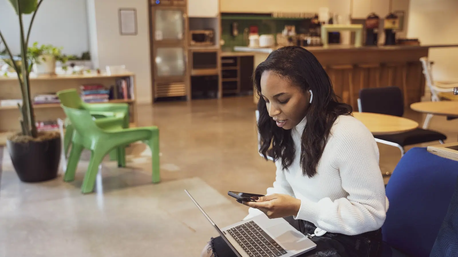 A woman working at a laptop in a bright open room