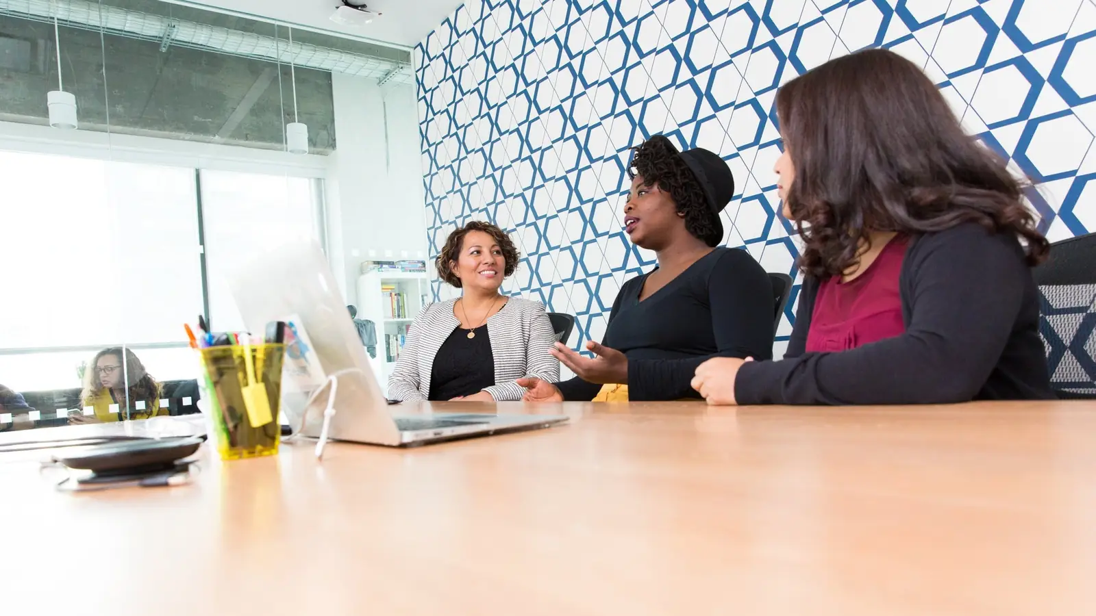 Three colleagues meeting at a table in a bright room