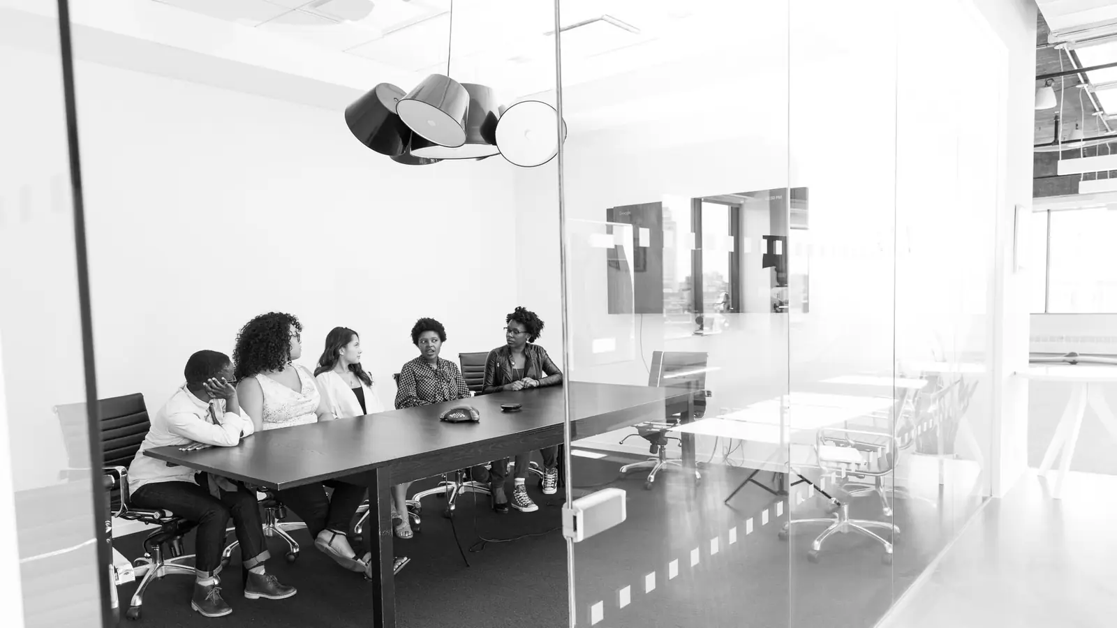 A working session underway in a glass-walled meeting room