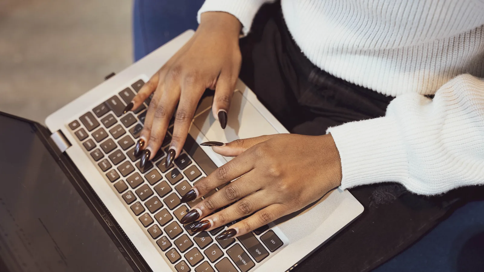 Close view of hands typing on a laptop