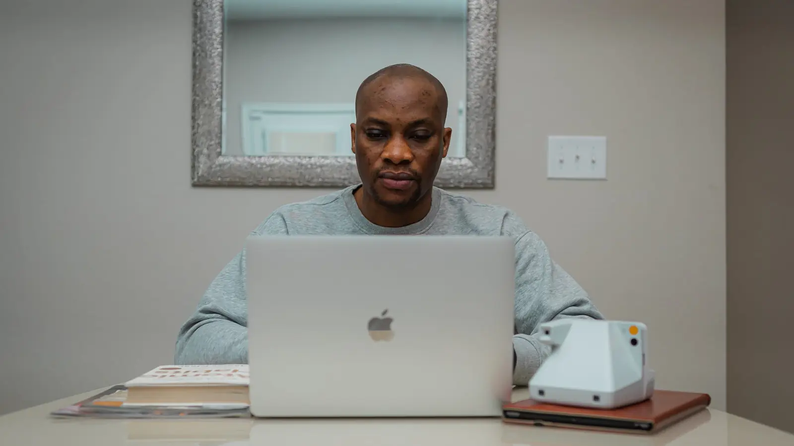 A man working at a laptop at a home office desk