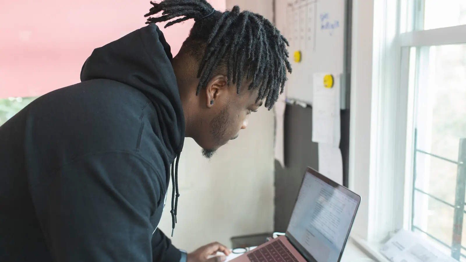 A man working at a laptop beside a microphone