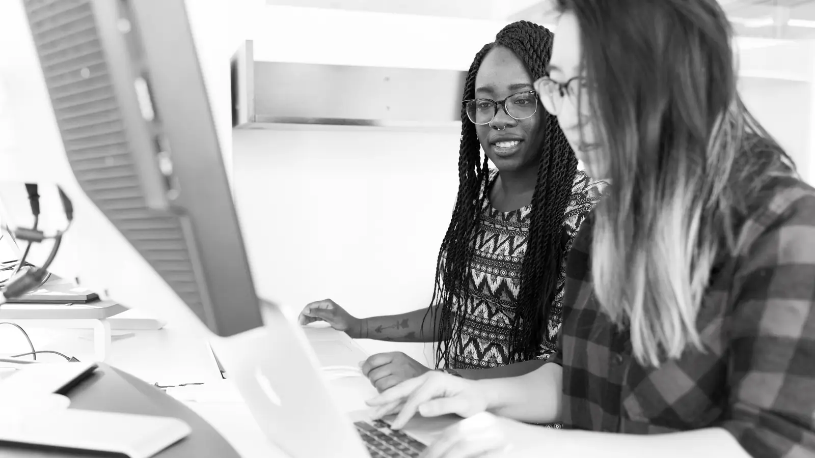 Two colleagues looking at the same monitor
