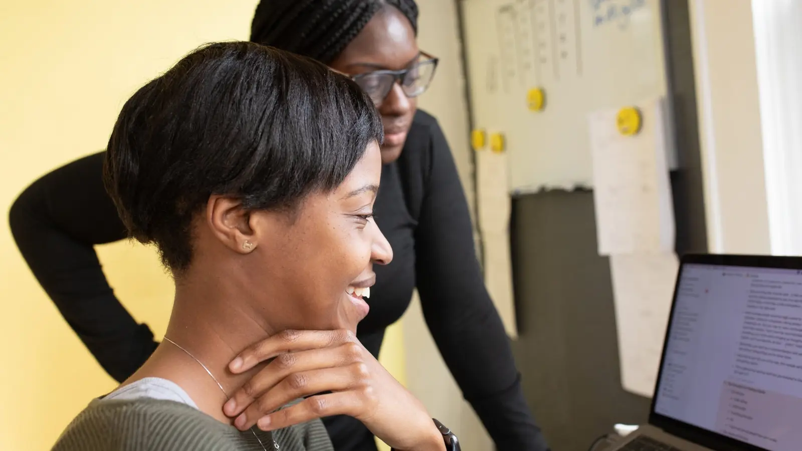 Two women looking at a computer together