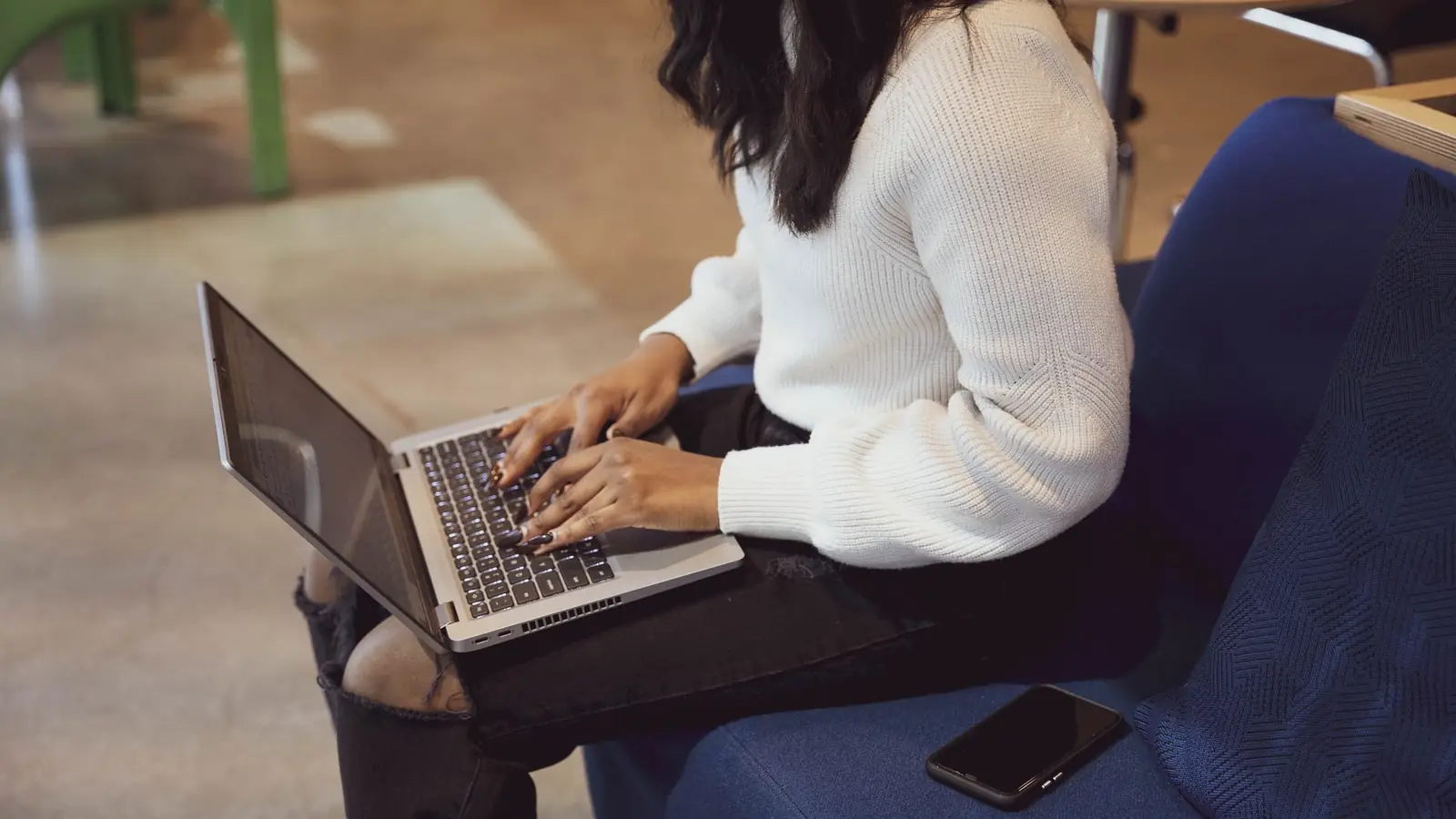 A woman working on a laptop while seated