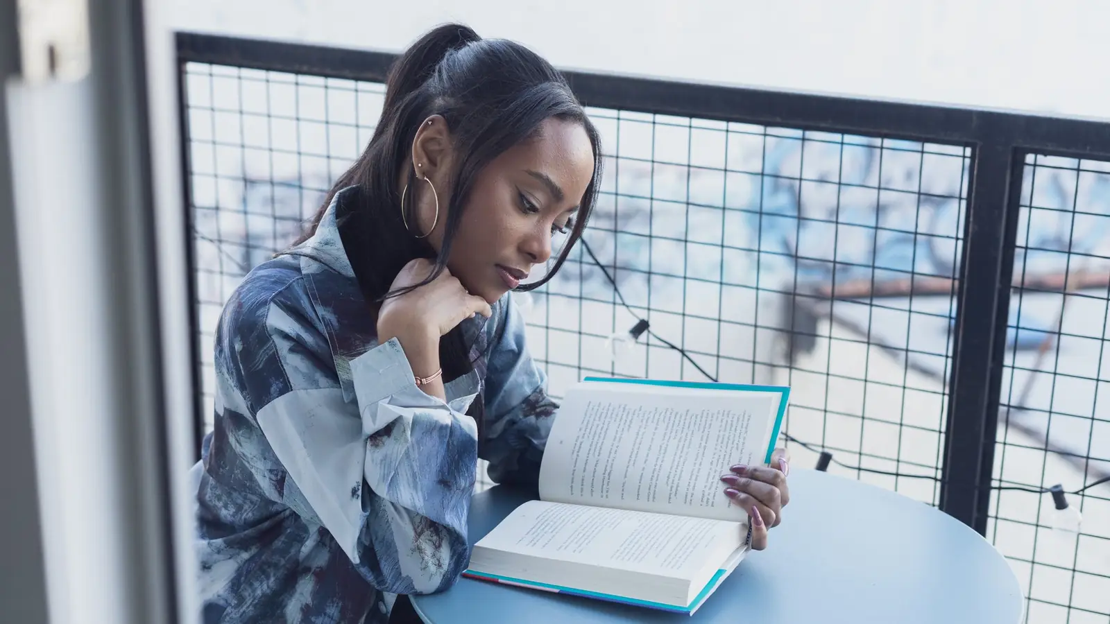 A woman reading and taking notes beside a window