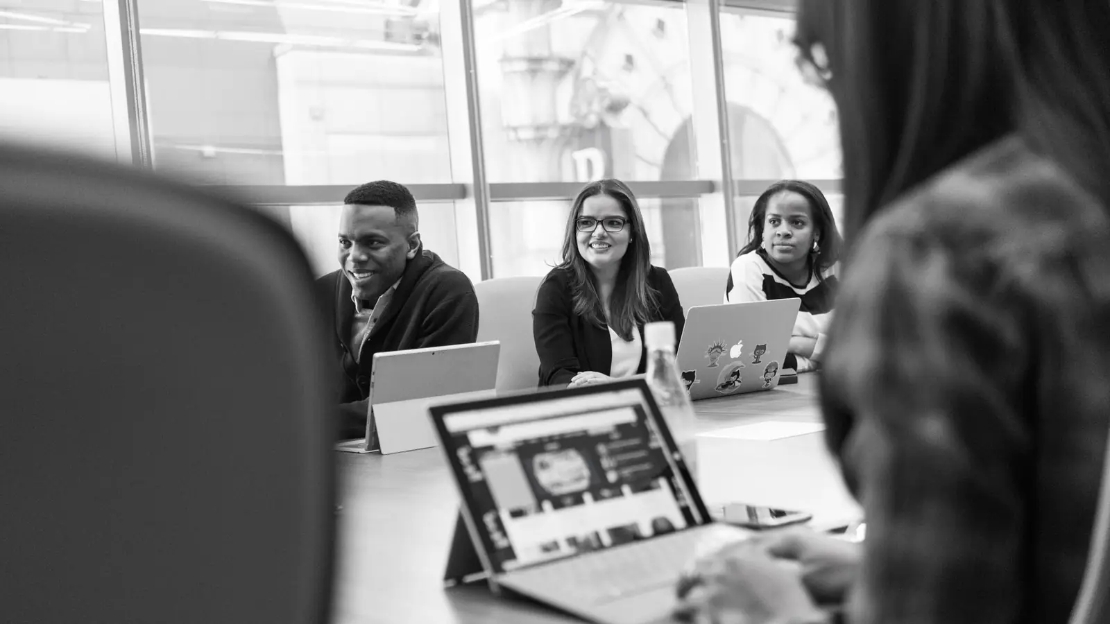 Colleagues at a table with a laptop open