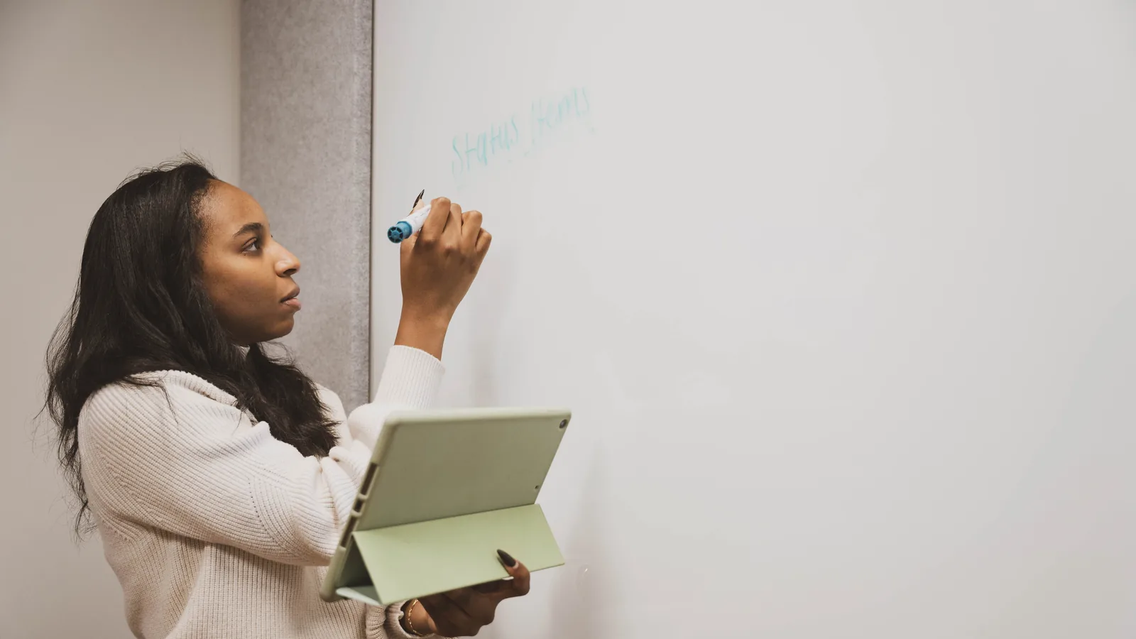 An instructor working from a tablet at a whiteboard