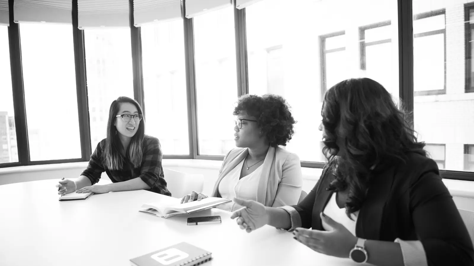 Three colleagues seated at a boardroom table