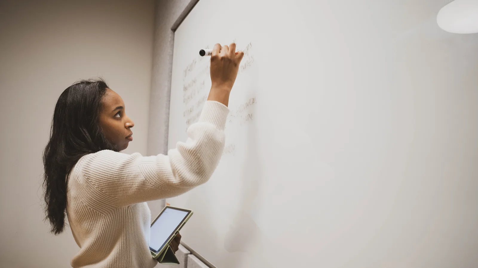 An instructor writing on a whiteboard